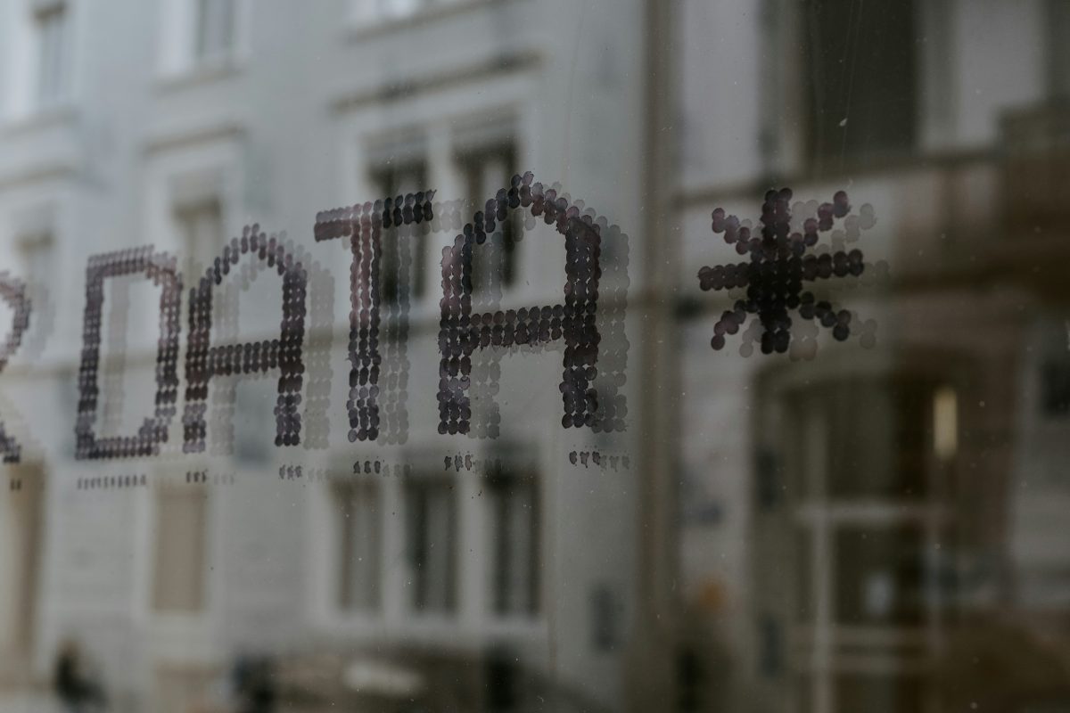 The word "DATA" followed written in a dark, dotted pattern on a glass window .